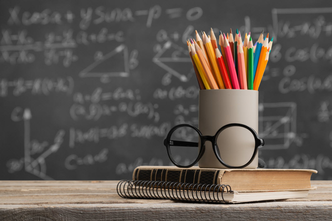 Image of a blackboard pencils and a book