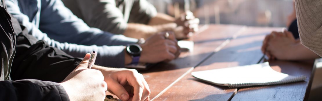 Group of People at a Meeting Table with Papers