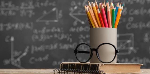 Image of a blackboard pencils and a book