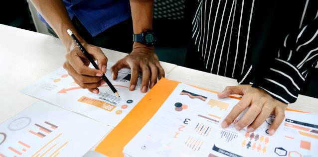 Two team members reviewing graphs and charts of data