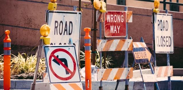 Barriers on a road closing it off to traffic, with signs saying "Road Closed" and "Wrong Way"