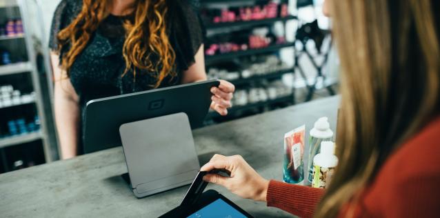 Customer sales woman processing payment for another woman with credit card